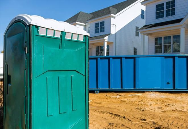 a line of portable bathrooms on a busy construction site